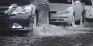 在道路上行驶的汽车带有地表水。交通雨水和道路积水。