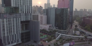 香港/ 2018年3月28日:香港城市鸟瞰图，摩天大楼高玻璃建筑。汽车、公共交通在街道上行驶，运动场附近的交通十字路口。日落烟雾灰色的天空。锅。