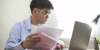 亚洲人支付账单的笔记本电脑，家庭财务概念