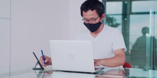 穿着休闲服的亚洲人，戴着口罩以保护自己免受冠状病毒感染。在网上搜索和申请工作。,社会距离