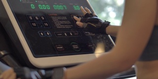 年轻漂亮的女人在健身房锻炼在跑步机上跑步