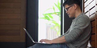 新冠肺炎疫情期间，亚洲年轻商人利用笔记本电脑召开视频会议，与居家隔离的同事进行在线工作交流