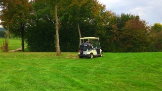 高尔夫球手驾驶高尔夫球车与高尔夫球袋在高尔夫球场视频素材模板下载