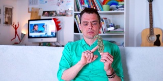 视频博主谈论大麻。手里拿着大麻，