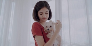 年轻女子和西施犬在床上