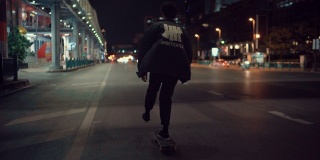 年轻人晚上沿着城市街道玩滑板