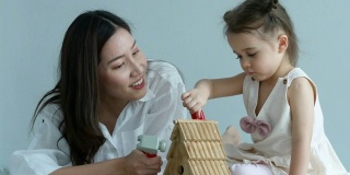 妈妈教小女孩玩玩具，家庭教育的概念