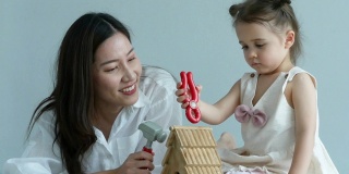 妈妈耐心地教小女孩玩玩具，在家上学的观念，小女孩打喷嚏