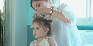 母亲整理女儿的头发，在家教育的理念