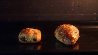 迷你巧克力面包和羊角面包在烤箱自制延时拍摄4K深色背景视频素材模板下载
