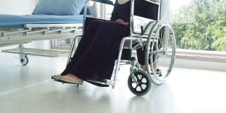 穆斯林妇女医生照顾穆斯林妇女。女医生用轮椅把病人送到床上
