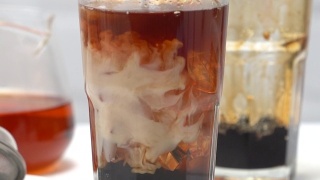 泡奶茶，将牛奶和茶倒入红糖图案的水杯中，放置在白色的木桌背景上视频素材模板下载