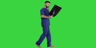 外科医生在绿色屏幕上行走时研究核磁共振脑部扫描
