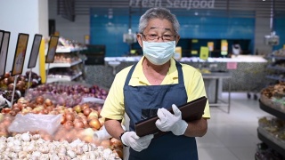 一名亚洲华人高级男子，超市店主，零售助理，戴着口罩视频素材模板下载