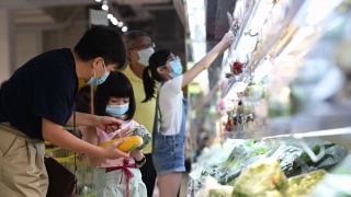 一个亚洲华人家庭周末在超市的冷藏区购买蔬菜视频素材模板下载