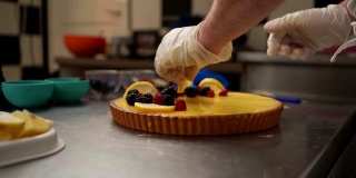 厨师用浆果和柠檬装饰起司蛋糕