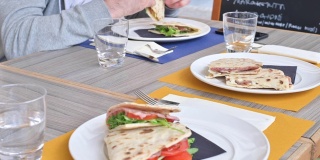 罗马尼亚艾米利亚地区的传统意大利广场，有各种馅料。服务员把盘子和午餐端上了桌子。在意大利餐厅吃午餐。