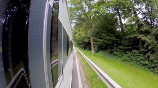 一辆车拖着一辆大篷车行驶在乡间的巴伐利亚路上视频素材模板下载