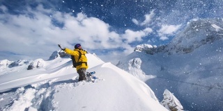 充满喜悦的滑雪板站在山顶的雪山在一个阳光明媚的冬日
