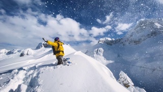 充满喜悦的滑雪板站在山顶的雪山在一个阳光明媚的冬日视频素材模板下载