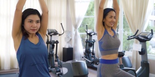 两位亚洲女性在运动服装训练和练习瑜伽教练为健康的生活方式。