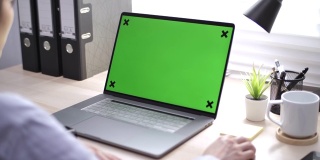 亚洲女人在桌上的笔记本电脑上使用彩色按键屏幕