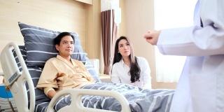 亚洲职业女医生在医院病房向病人解释。病人和他的妻子已经了解了所有的信息