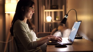 亚洲女人在家里使用笔记本电脑没有晚上视频素材模板下载