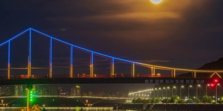 在一轮冉冉升起的满月的背景下，第聂伯河上一座人行桥上人们的剪影
