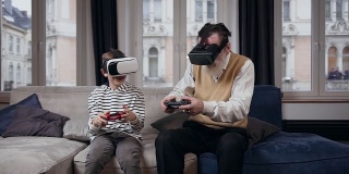 有魅力的大胡子老爷爷和他13岁的孙子一起用增强现实眼镜玩令人兴奋的电子游戏