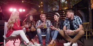 和朋友度过的美好时光。周末的晚上，四个年轻人坐在后院的椅子上聊着天，喝着啤酒