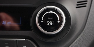 特写，按按钮打开汽车里的空调。男人的手按下了按钮