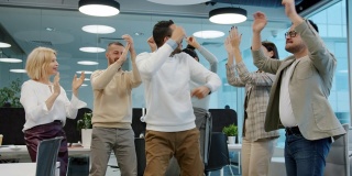 一名中东男子在公司活动上跳舞，同事们鼓掌