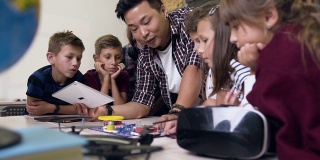 一组六名小学生，老师在课堂上使用数字平板电脑启动电子构造器风扇