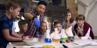一名亚洲科学教师为六名小学生做了一个实验，将干冰放入装有有色液体的烧瓶中，烧瓶中装有液体的干冰会产生烟雾