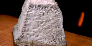 美味的金字塔瓦伦凯奶酪与灰色的霉菌在壁炉的背景