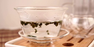 从茶壶里倒出绿茶。特写,茶道