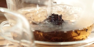 茶壶将红茶倒入玻璃杯中，特写微距，选择性聚焦