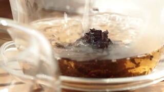 茶壶将红茶倒入玻璃杯中，特写微距，选择性聚焦视频素材模板下载