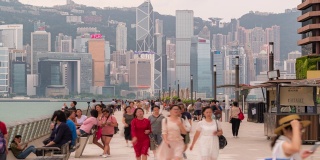 慢镜头:行人挤在星光大道上，背景是香港市中心的天际线