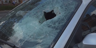 一辆破旧汽车的挡风玻璃破裂。