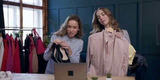 两个美丽的金发女人展示服装制作关于时尚风格的视频博客