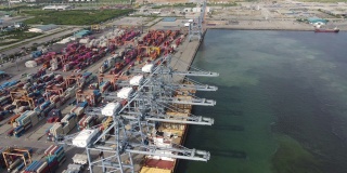 4K鸟瞰图多式联运船坞与一艘装载的集装箱船停靠在东南亚泰国的港口