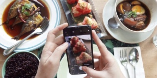 近距离的女人用智能手机拍照的食物