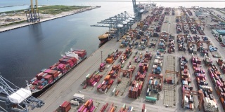 4K鸟瞰图多式联运船坞与一艘装载的集装箱船停靠在东南亚泰国的港口