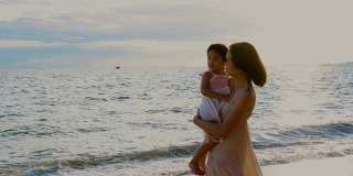 母亲在海滩上抱着女儿