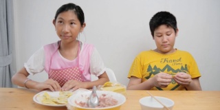 快乐亚洲小朋友在家一起包饺子，生活理念。