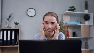 不开心的迷人的金发女孩按摩太阳穴，以缓解头痛时，她在现代橱柜的电脑视频素材模板下载