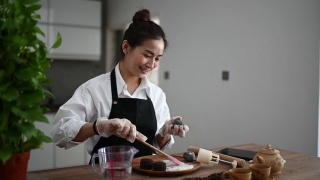 亚洲华人美丽的女人在她的厨房库存照片制作中国传统中秋节雪皮月饼…视频素材模板下载