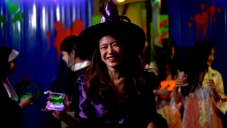 微笑的年轻女性在万圣节服装在万圣节派对上玩得开心视频素材模板下载